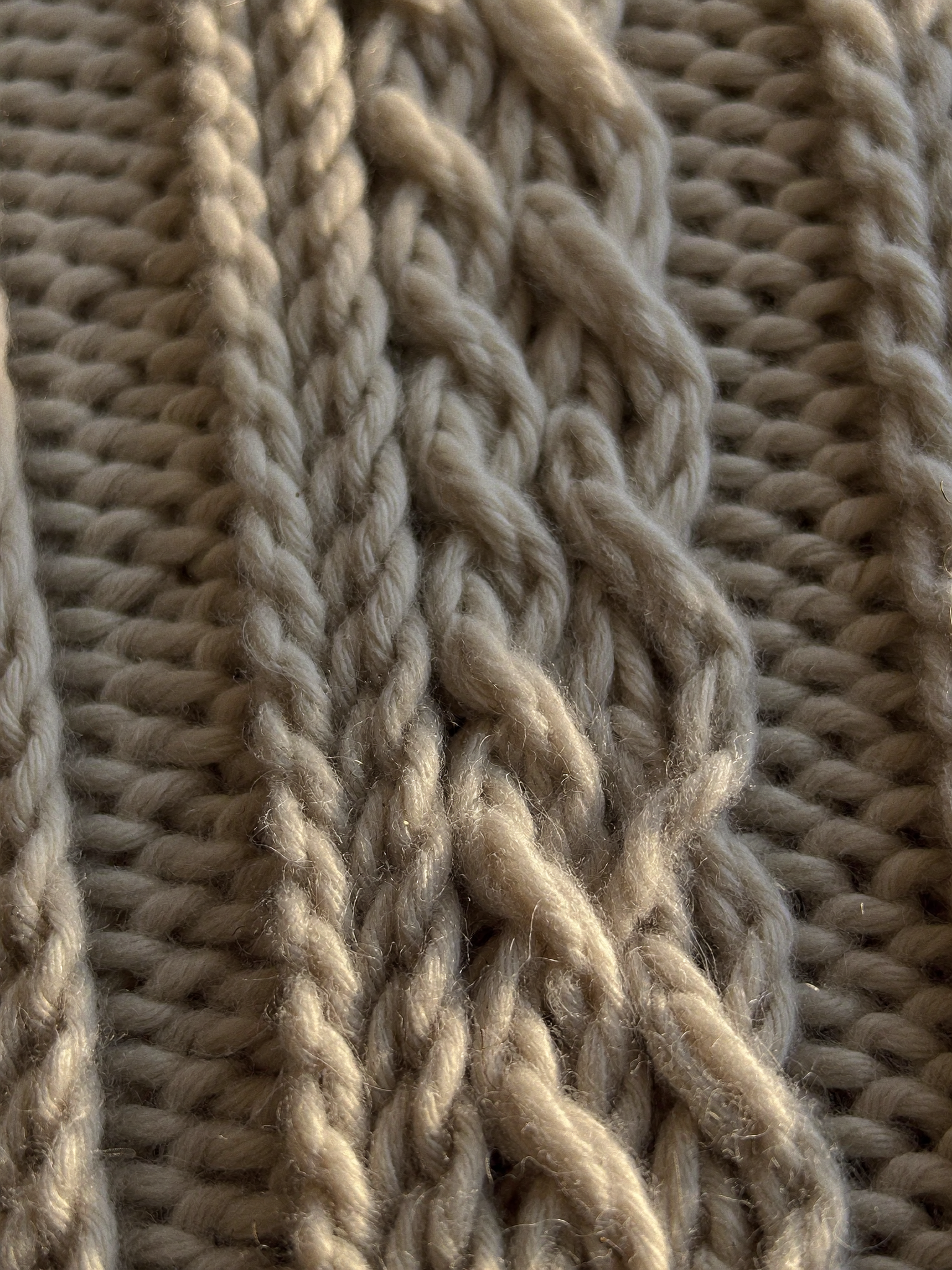 Close-up of hand-knitted cables in oatmeal merino wool