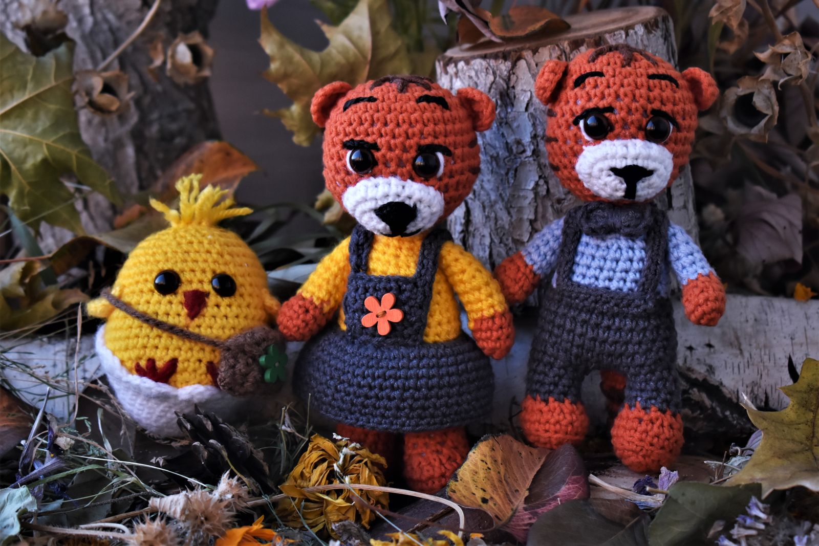Handmade crochet woodland animal toys among autumn leaves