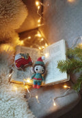 Festive crochet gnome with open book surrounded by warm lights