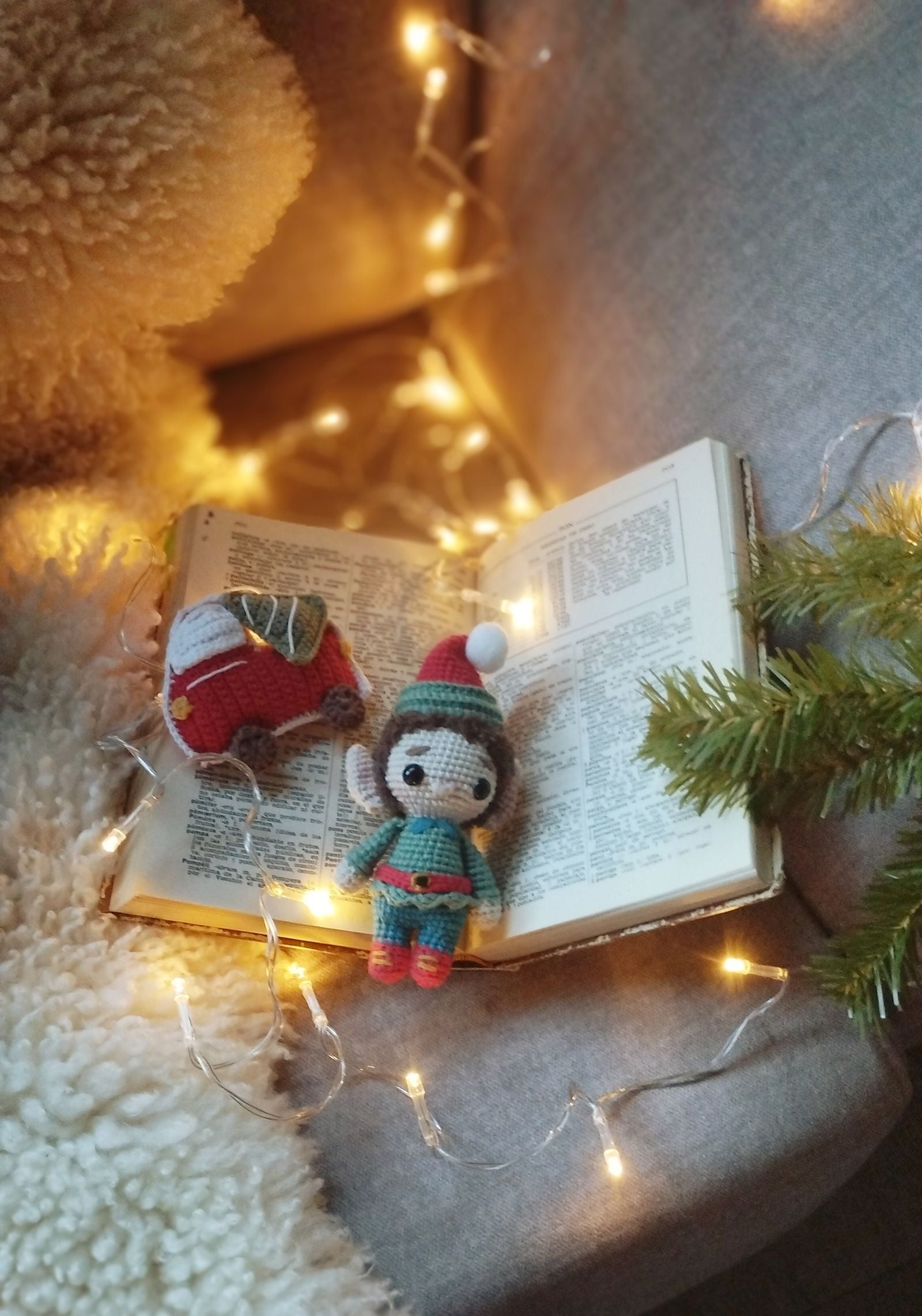 Festive crochet gnome with open book surrounded by warm lights